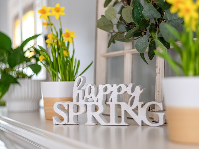 A mantel decorated with bright flowers.